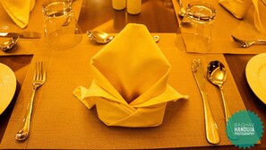 A table set with a folded napkin, cutlery, and glasses.