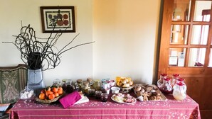 Une table avec divers aliments et des bocaux, un vase avec des branches et un tableau encadré au mur.