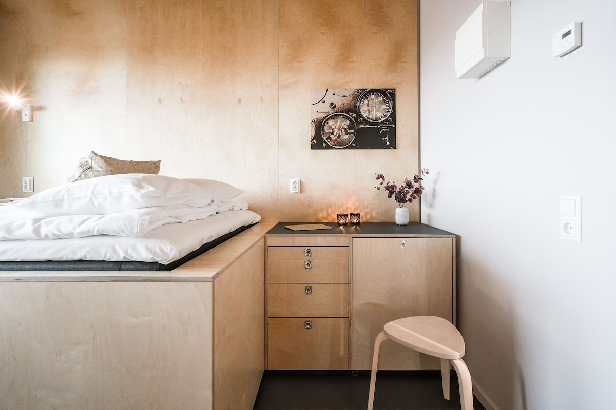 Ein modernes Schlafzimmer mit Bett, Schreibtisch und Stuhl.