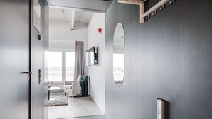 A modern hotel room with a large mirror, a small table, and a view of the outdoors. - Forenom Aparthotel Arlanda (Arlanda)