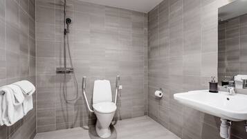 Een moderne badkamer met douche, toilet en wastafel.