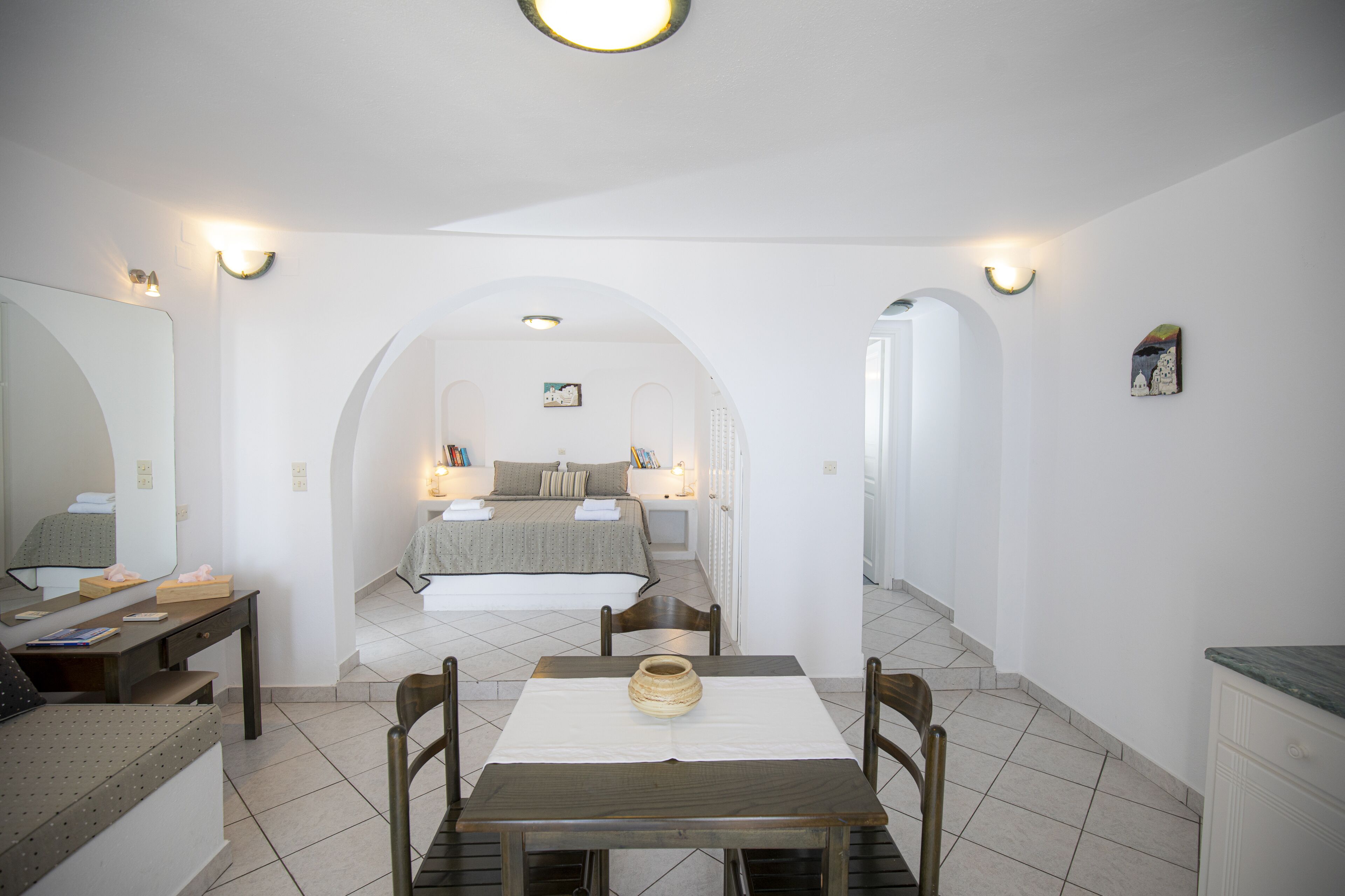 Una habitación de hotel con una cama, un escritorio, una silla, una mesa y una zona de comedor.
