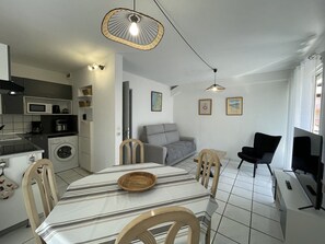 Um espaço compacto com área de jantar, cozinha compacta e espaço para sentar.