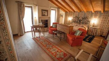 A cozy living room with a fireplace, wooden furniture, and a patterned rug.