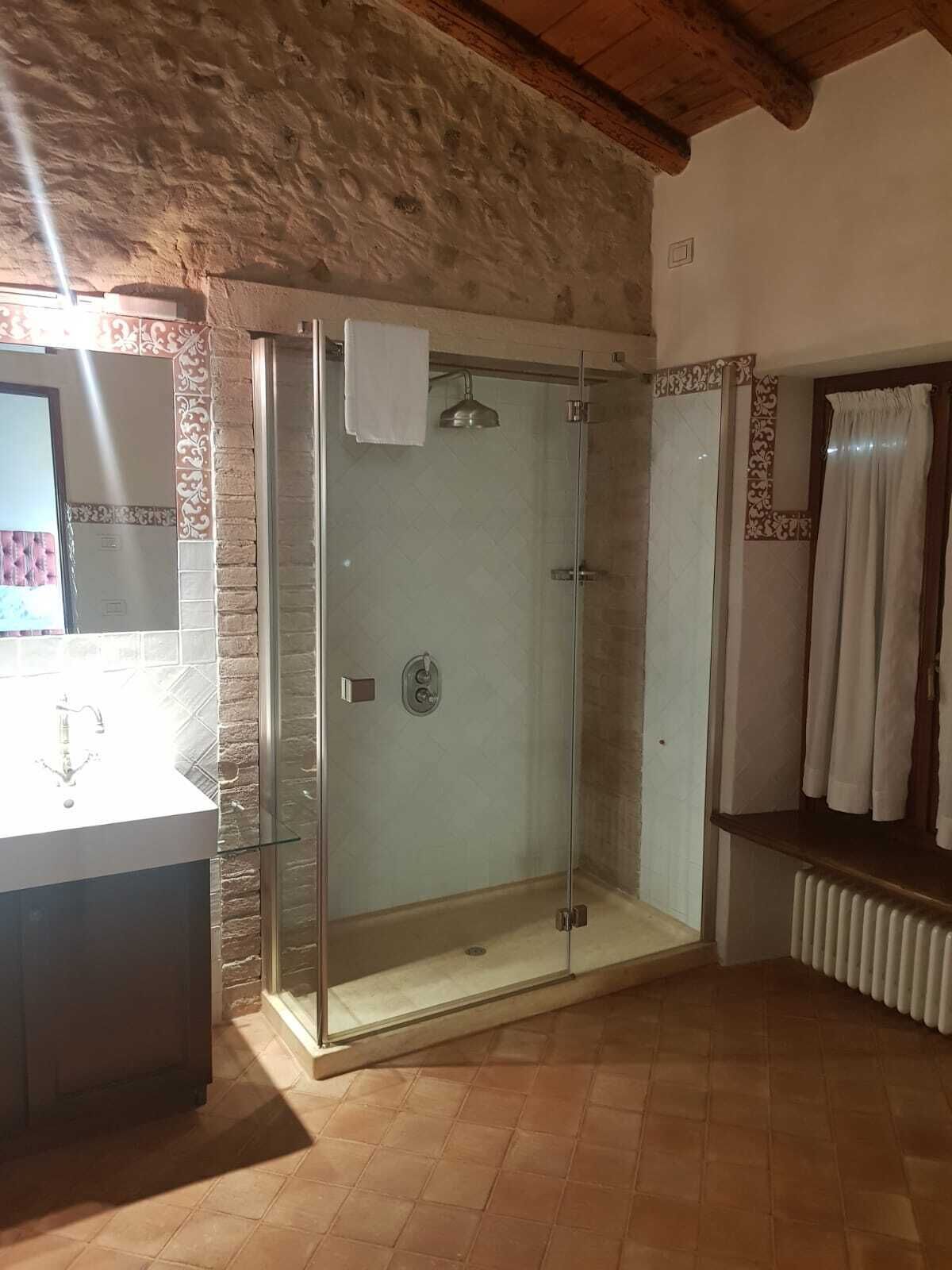 Ein Badezimmer mit einer Dusche in Glasabtrennung, einem Waschbecken und einem Handtuchhalter.