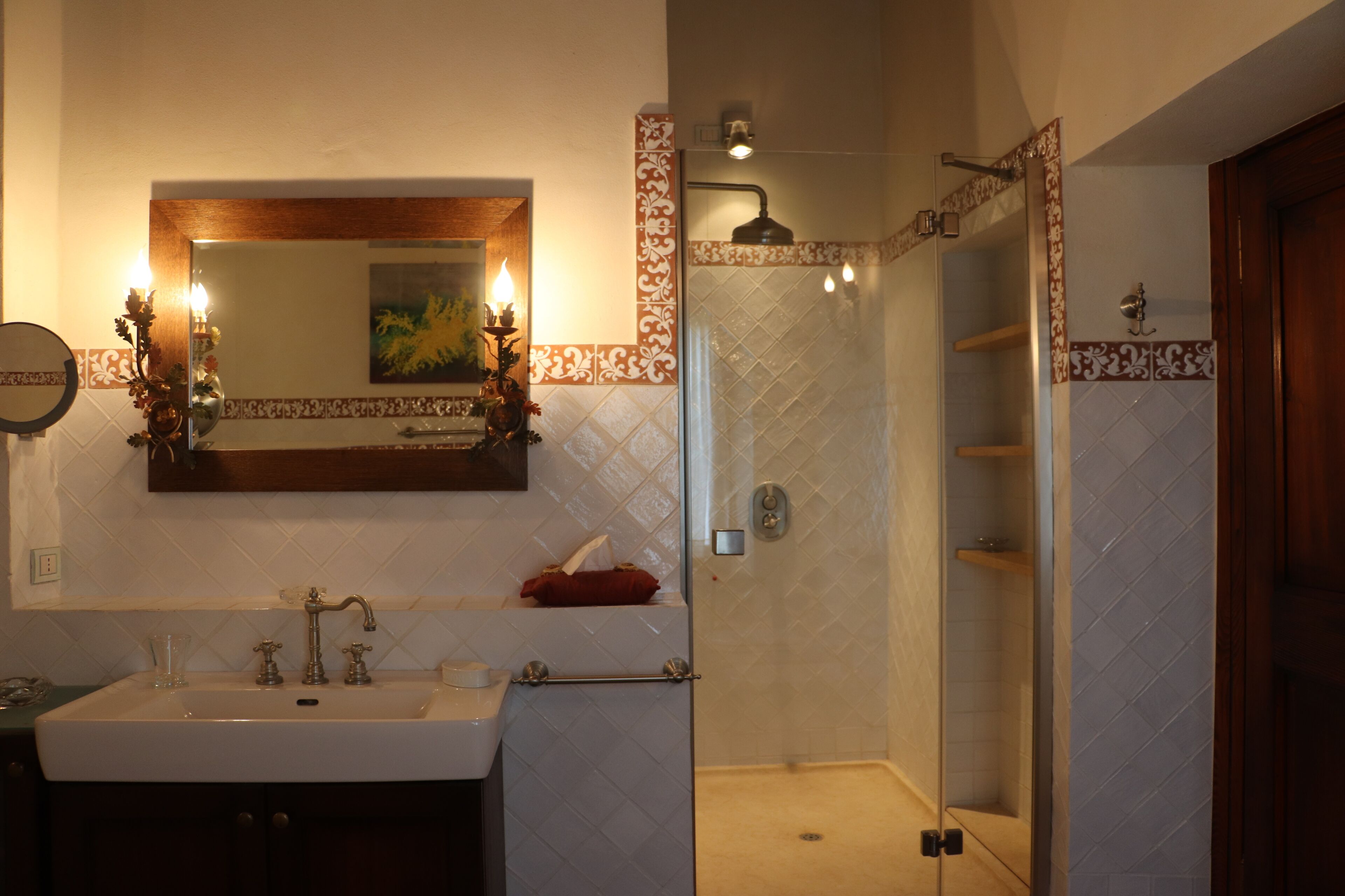 Un bagno con lavandino, specchio e doccia.