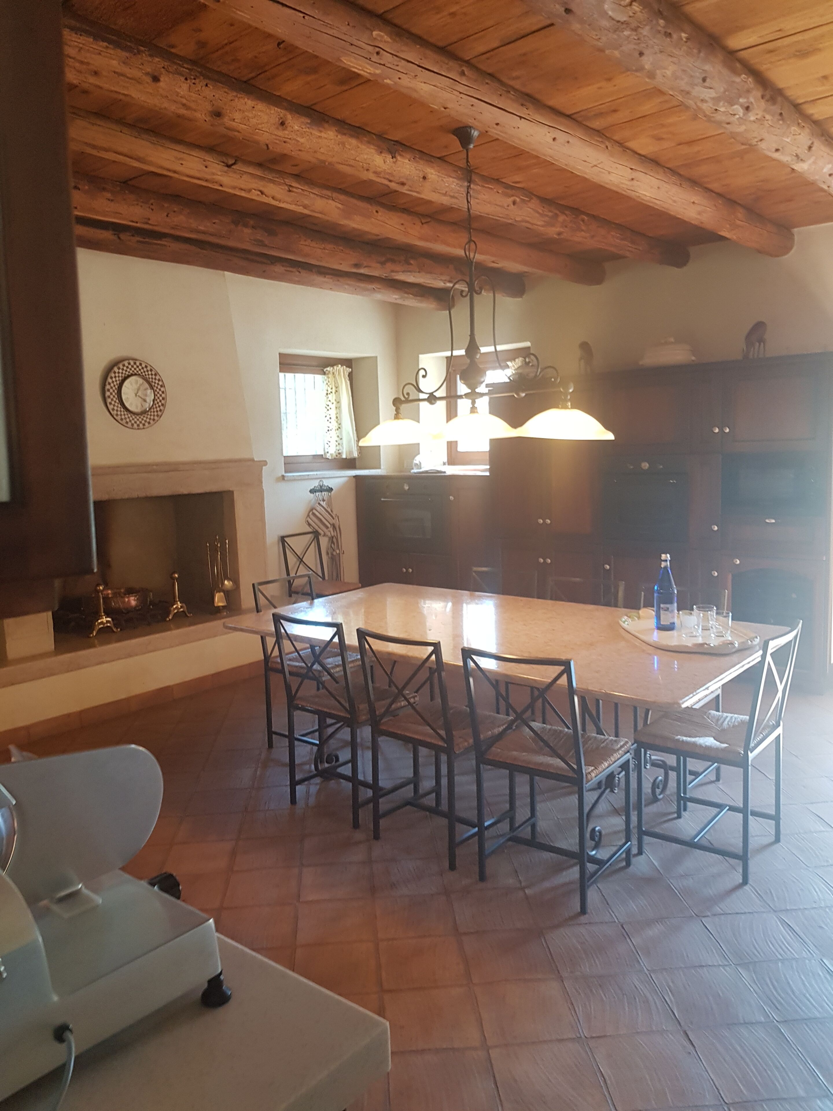 A spacious kitchen with a large island, wooden ceiling beams, and modern appliances.