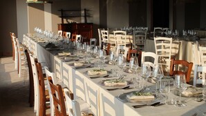 Una larga mesa de comedor con sillas, vasos y platos, que sugiere un espacio formal para comer.