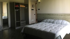 Un dormitorio con una cama grande, un armario y un espejo.