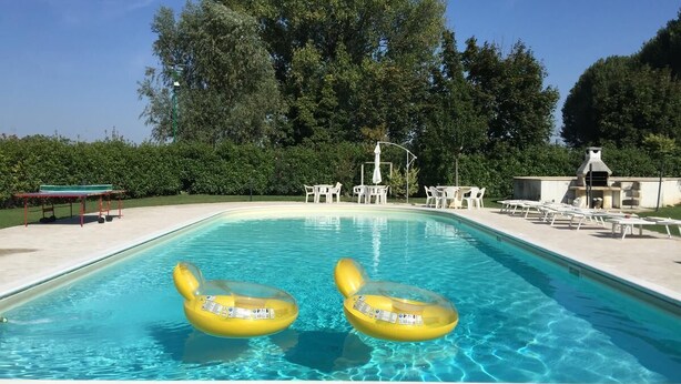 Una piscina al aire libre de temporada, sombrillas