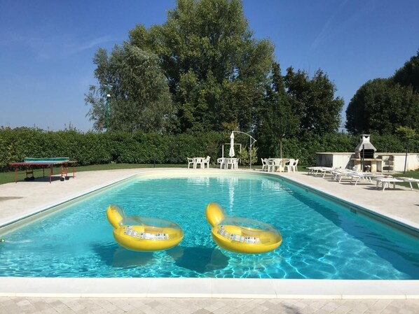 季節性室外游泳池，提供泳池遮陽傘和日光浴躺椅