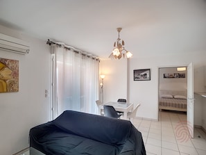 Una habitación de hotel con cama, escritorio con silla, candelabro y área de comedor.
