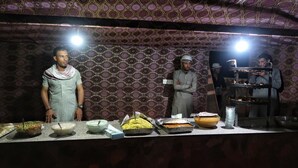 A buffet setup with various food items and a person in a uniform. - Wadi Rum Desert Camp (Wadi Rum)