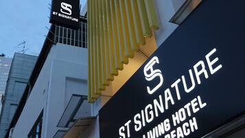 Un letrero de hotel con el nombre 'St. Signature' y 'Co-Living Hotel Bugis Beach'.