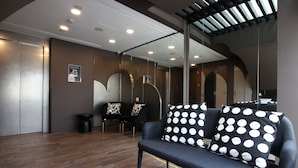 Un intérieur moderne avec un canapé, des fauteuils et un miroir.