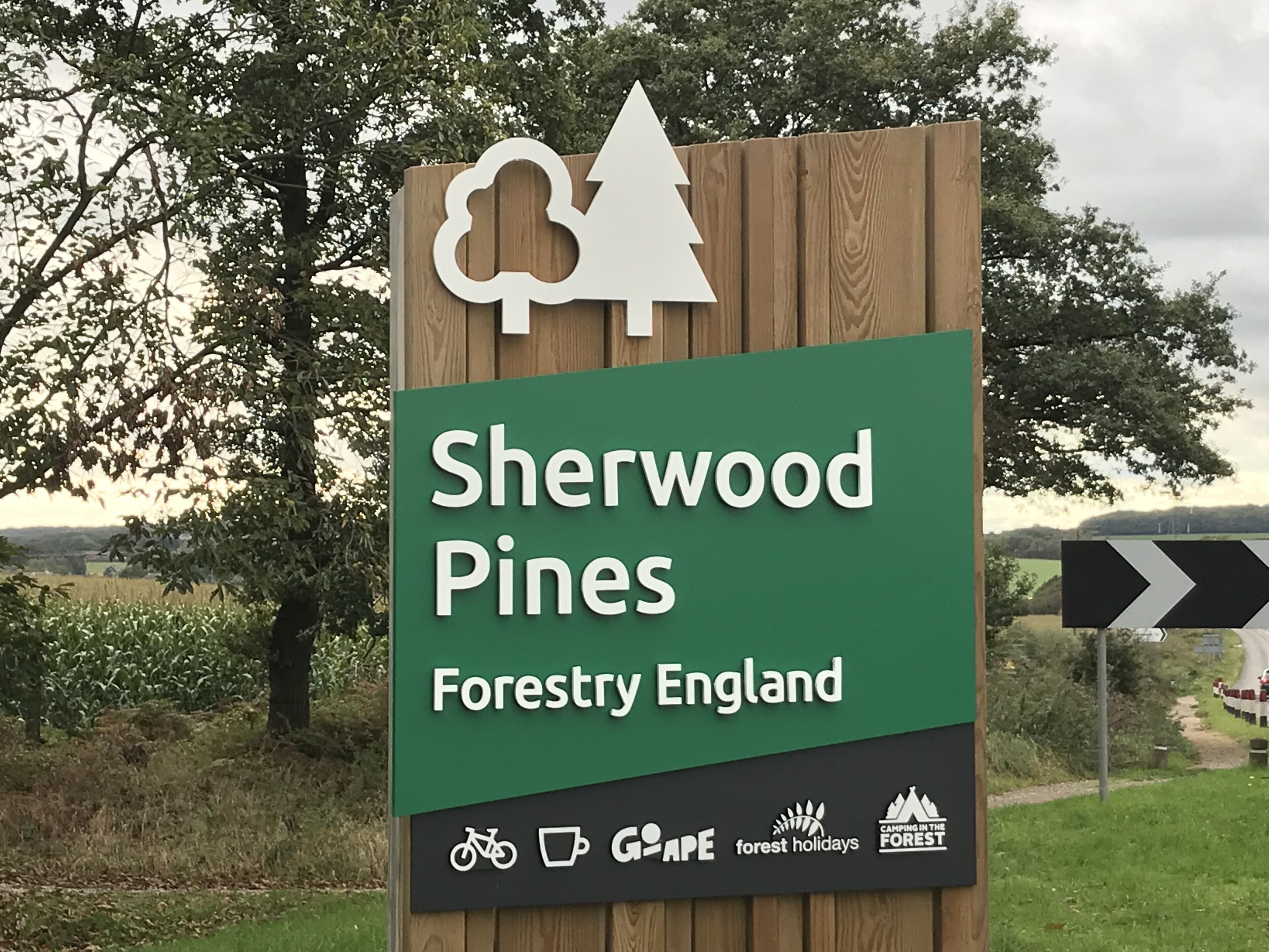 A sign for Sherwood Pines Forestry England with symbols for cycling, a coffee cup, and camping.