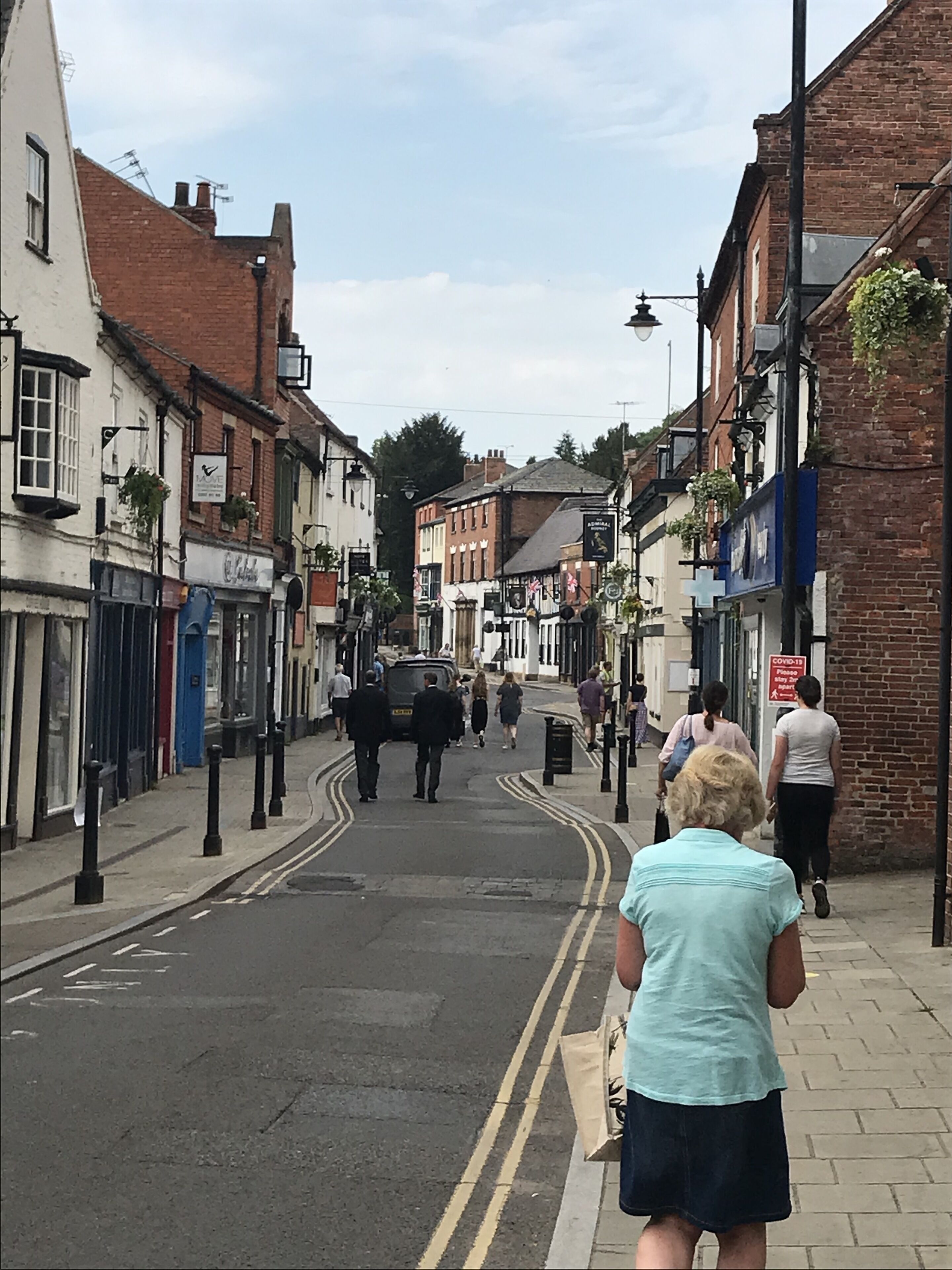 A street lined with traditional buildings, some with signage, and a few pedestrians.