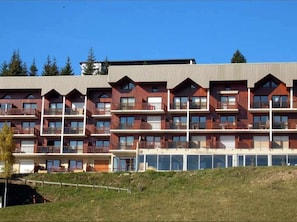 A multi-story hotel with balconies and large windows.