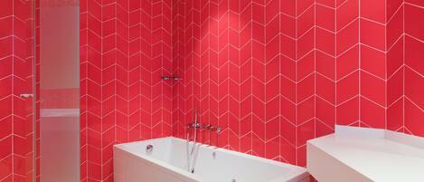 A modern bathroom with a red herring-patterned wall, a white bathtub, and a white sink.