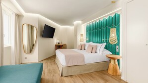 A modern bedroom with a bed, bedside table, and a TV mounted on the wall.
