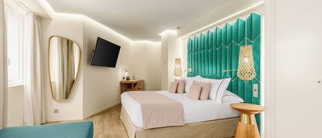 Un dormitorio moderno con cama, mesita de noche y televisor montado en la pared.