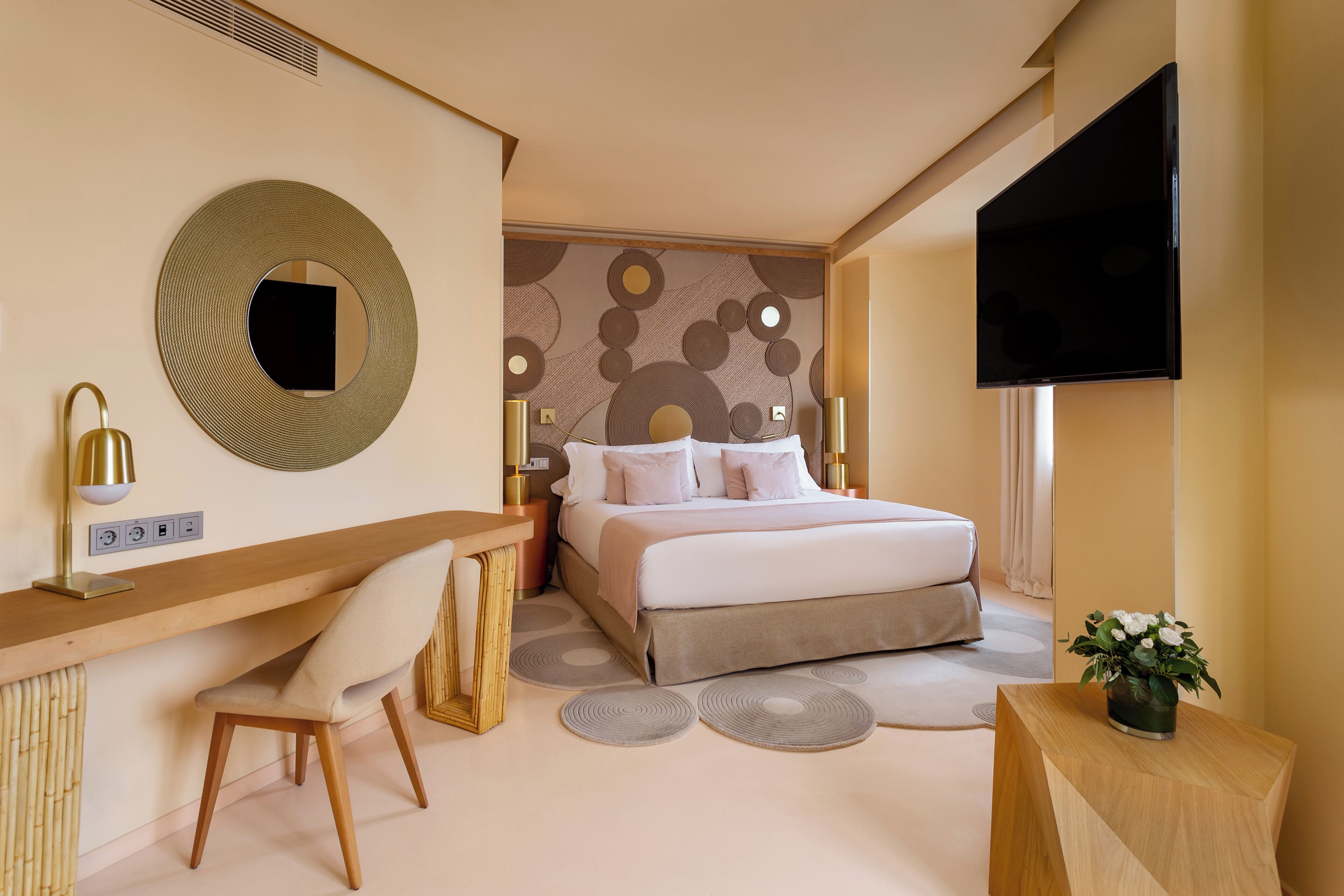 Ein modernes Schlafzimmer mit Bett, Schreibtisch, Stuhl und Fernseher.