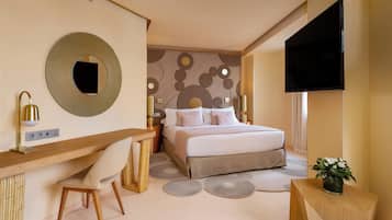 Ein modernes Schlafzimmer mit Bett, Schreibtisch, Stuhl und Fernseher.
