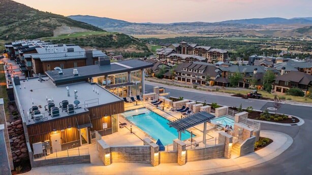 Een resort met een zwembad, terras en uitzicht op het omliggende landschap.