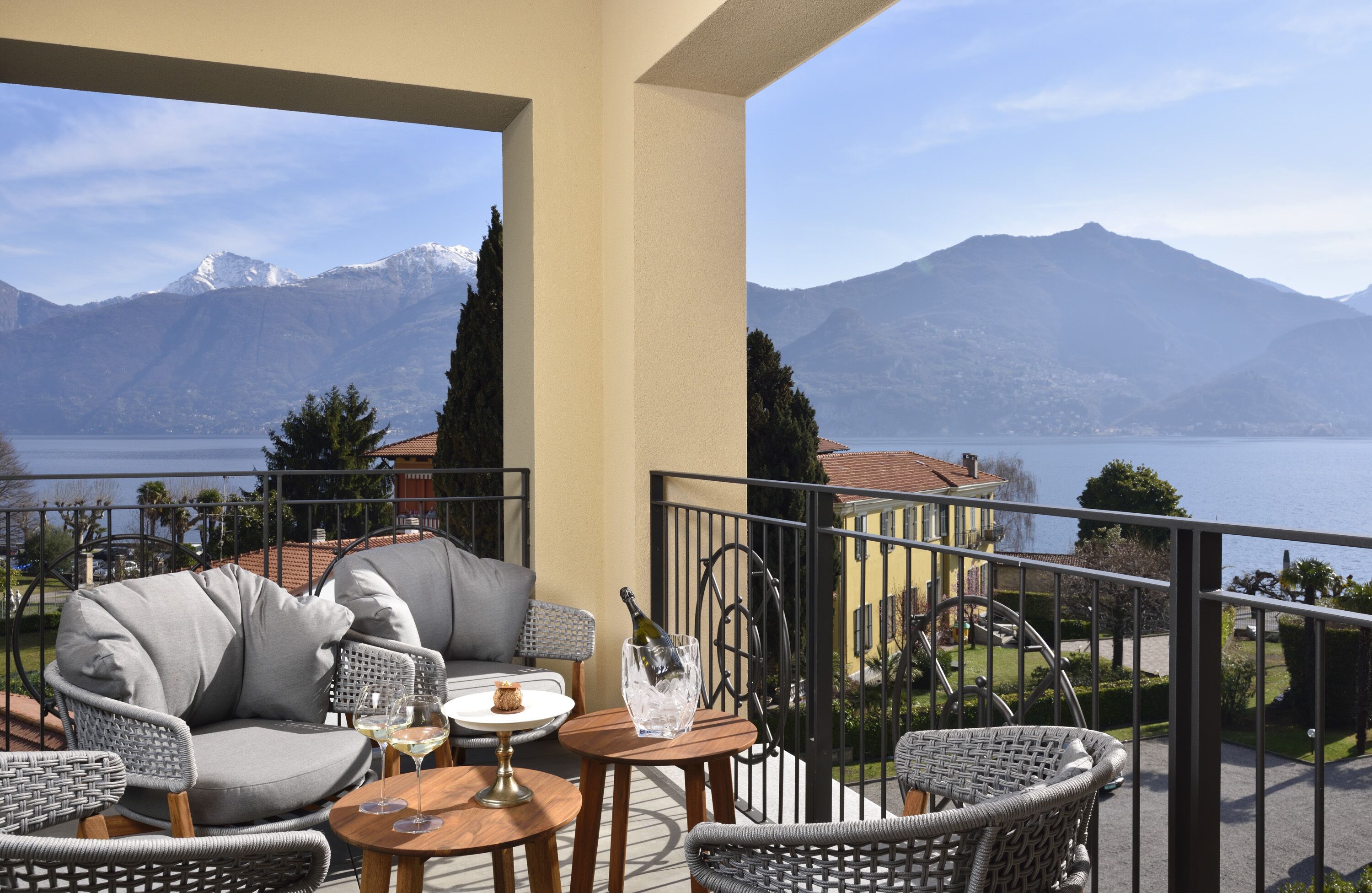 Ein Balkon mit Korbmöbeln, einer Champagnerflasche und einem Weinglas.