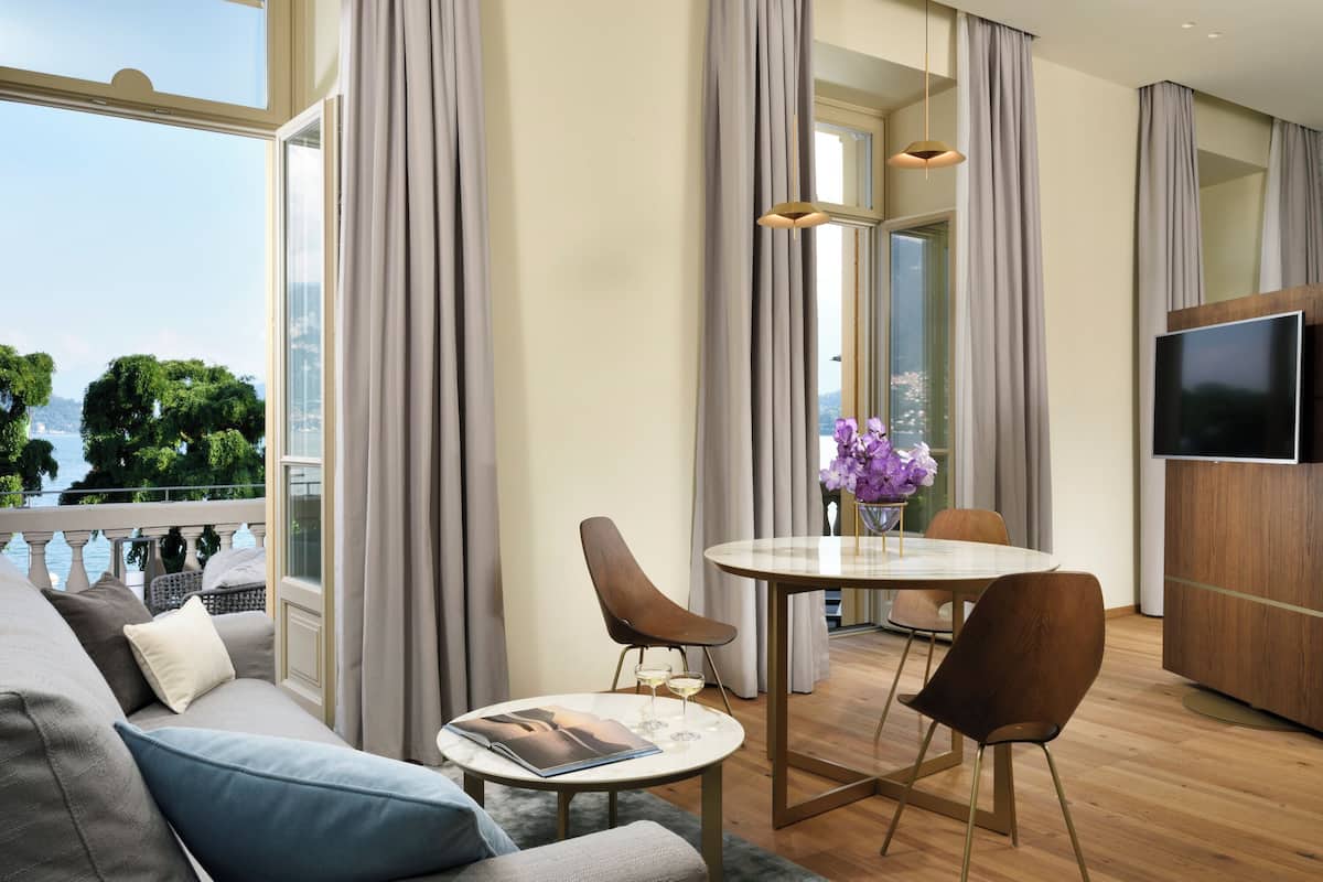 A modern living room with a sofa, a round dining table, and a TV.