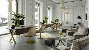 A spacious living area with a large wooden table, comfortable seating, and a view through a large window. - Grand Hotel Victoria Concept & Spa, by R Collection Hotels (Menaggio)