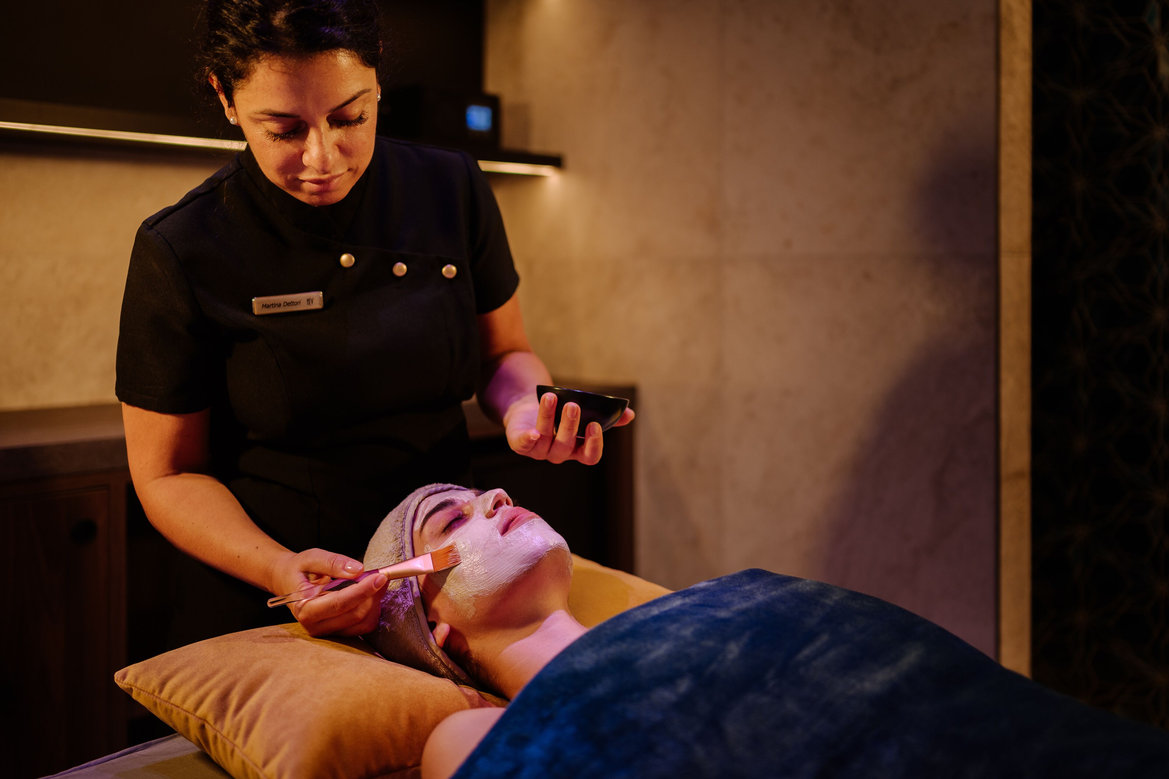 A person receiving a facial treatment in a spa setting.