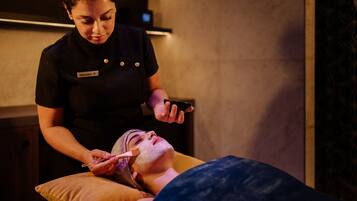 A person receiving a facial treatment in a spa setting.