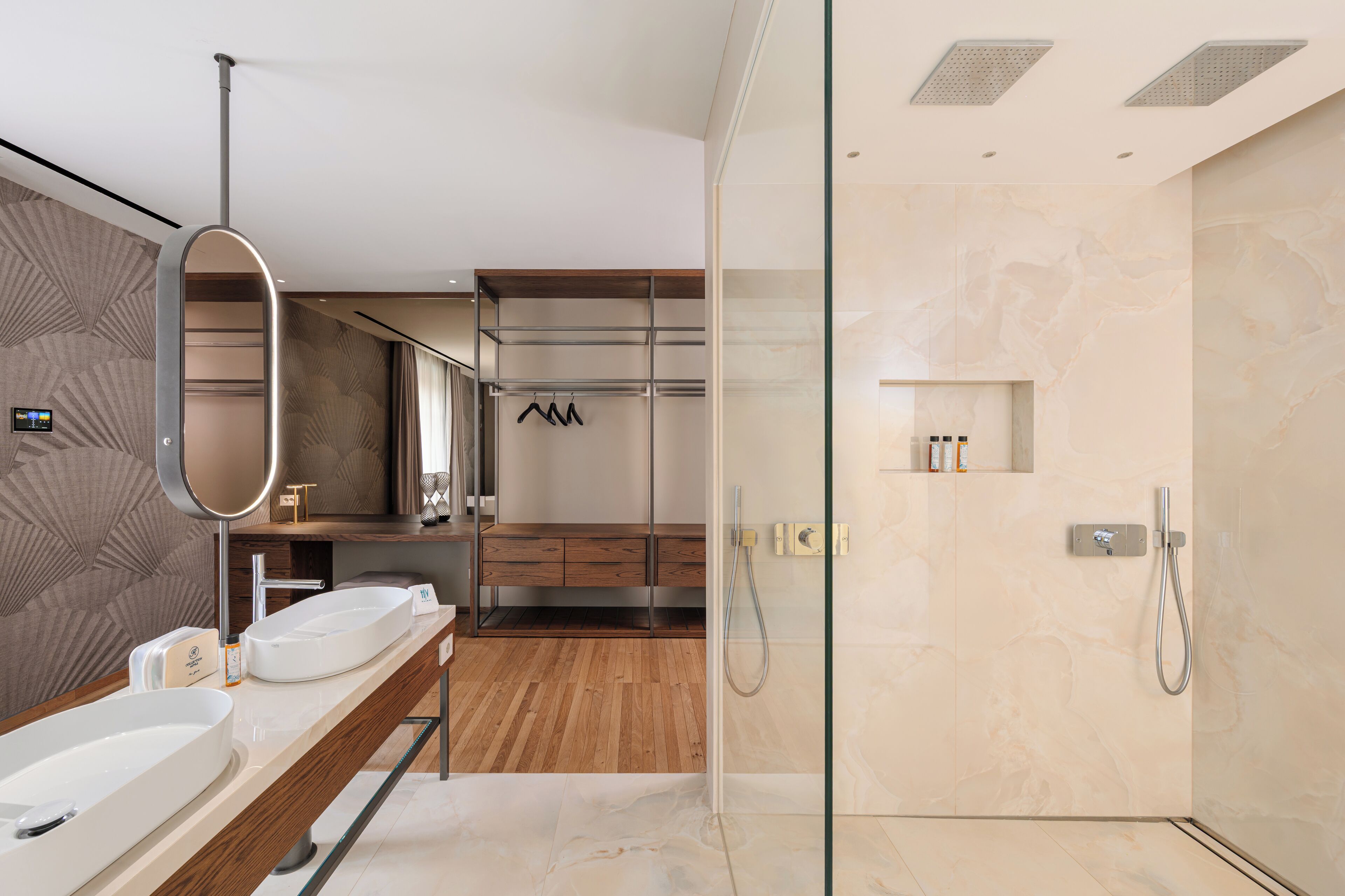 A modern bathroom with a glass-enclosed shower, wooden vanity, and a large mirror.