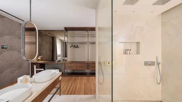 A modern bathroom with a glass-enclosed shower, wooden vanity, and a large mirror.