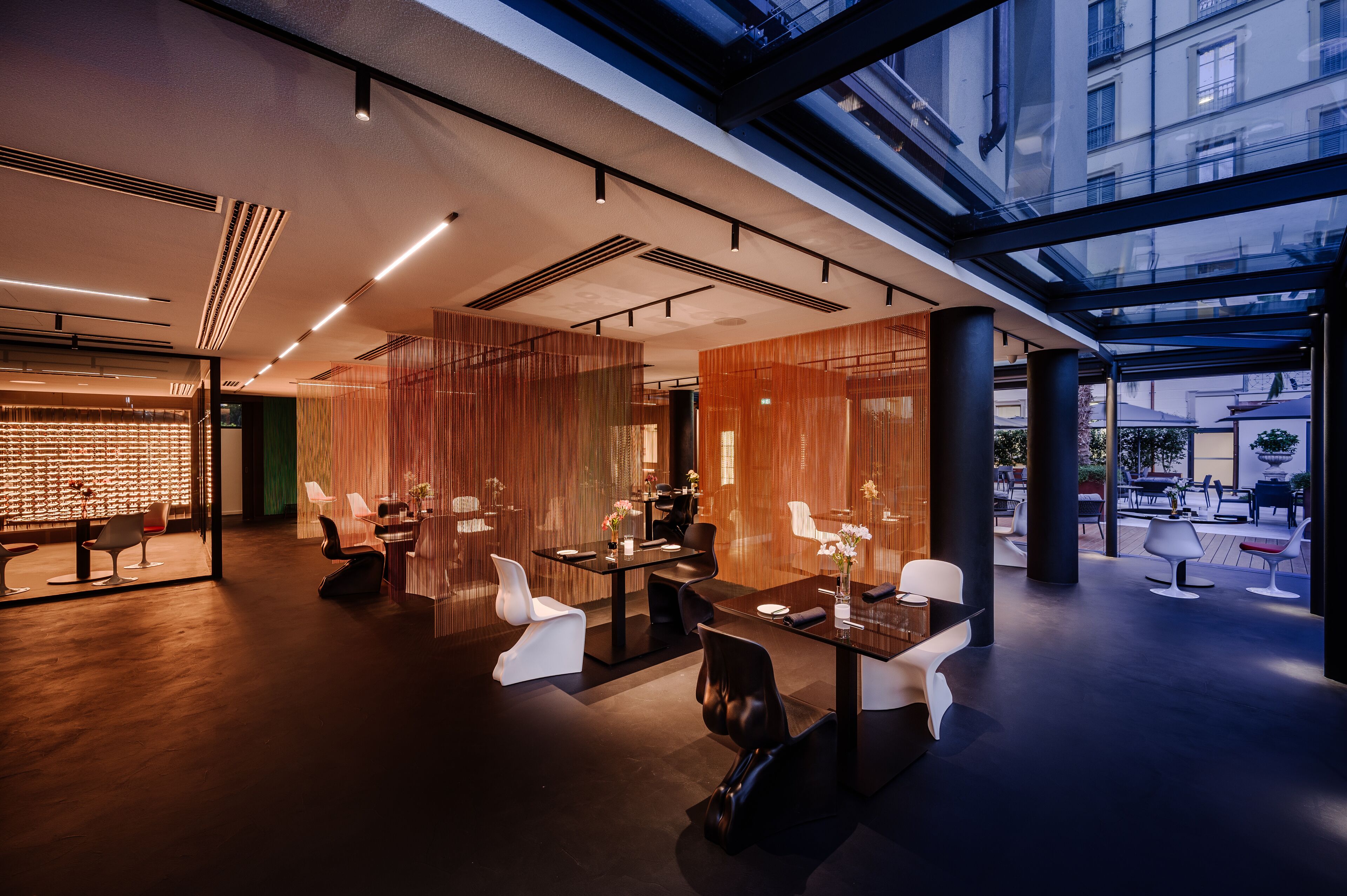 A modern interior with a glass ceiling, contemporary furniture, and a view of the city.