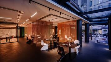 A modern interior with a glass ceiling, contemporary furniture, and a view of the city.