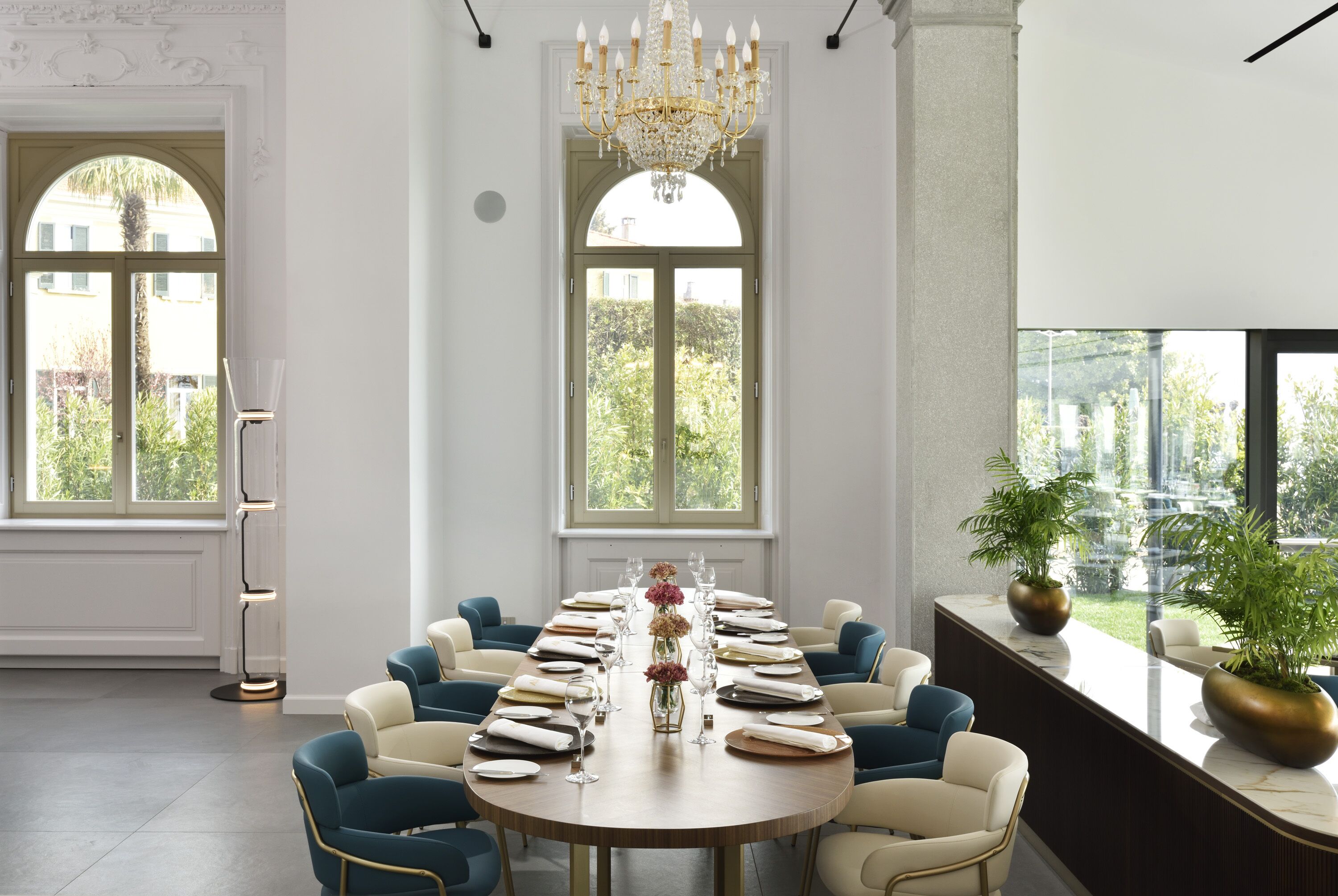 Un comedor formal con una mesa redonda dispuesta para una comida, rodeada de sillas.
