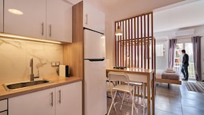 A modern kitchen with a marble backsplash, stainless steel sink, and wooden accents.