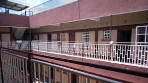 A multi-story building with balconies, railings, and windows.