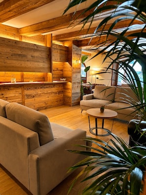 A cozy living area with a sofa, a round coffee table, and a plant.