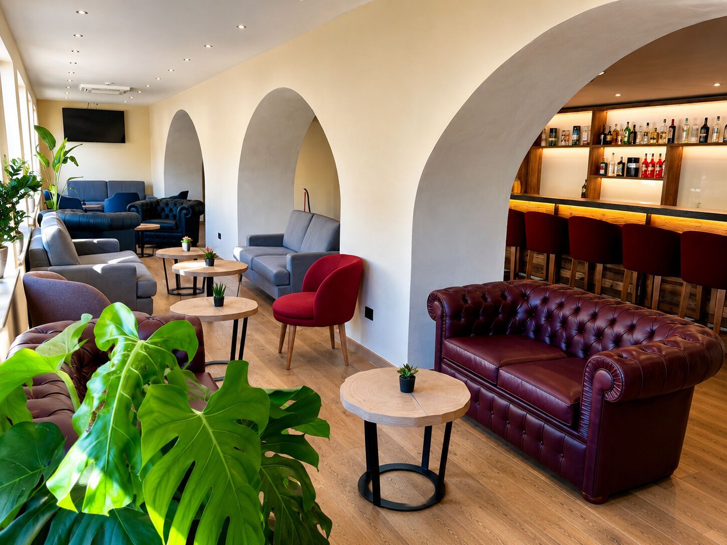 A modern lounge area with sofas, chairs, and a bar.