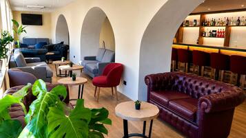 A modern lounge area with sofas, chairs, and a bar.