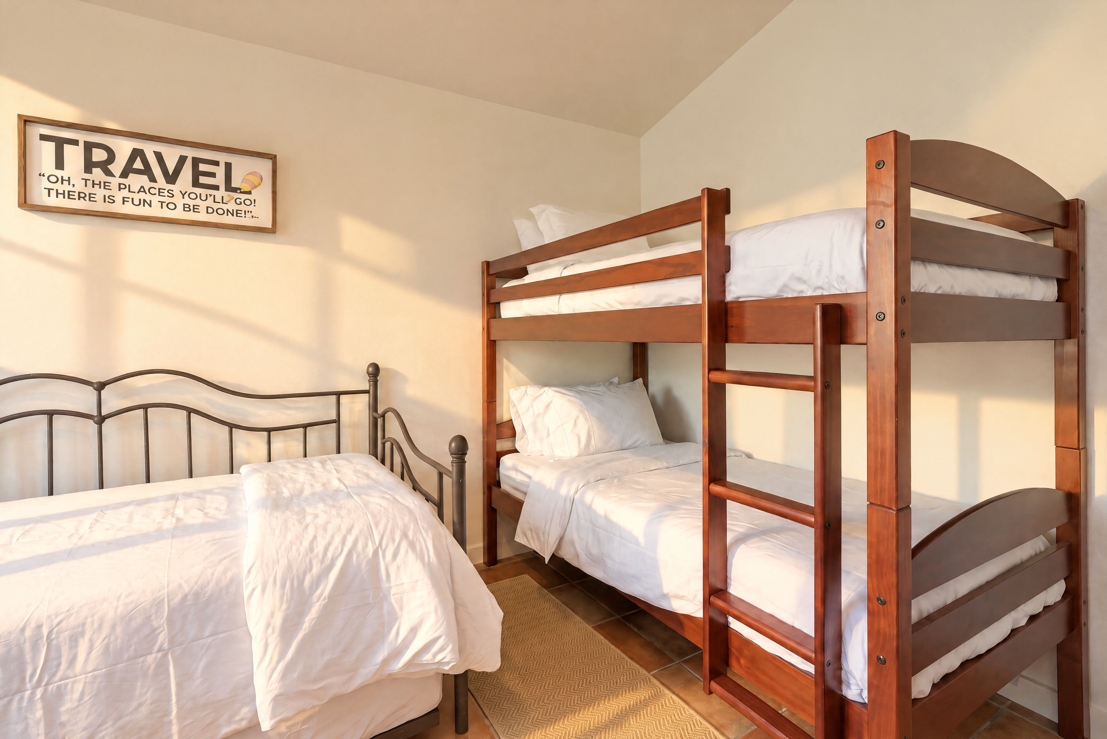 A bunk bed room with a wooden headboard, a single bed, and a wall-mounted sign.