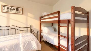 A bunk bed room with a wooden headboard, a single bed, and a wall-mounted sign.