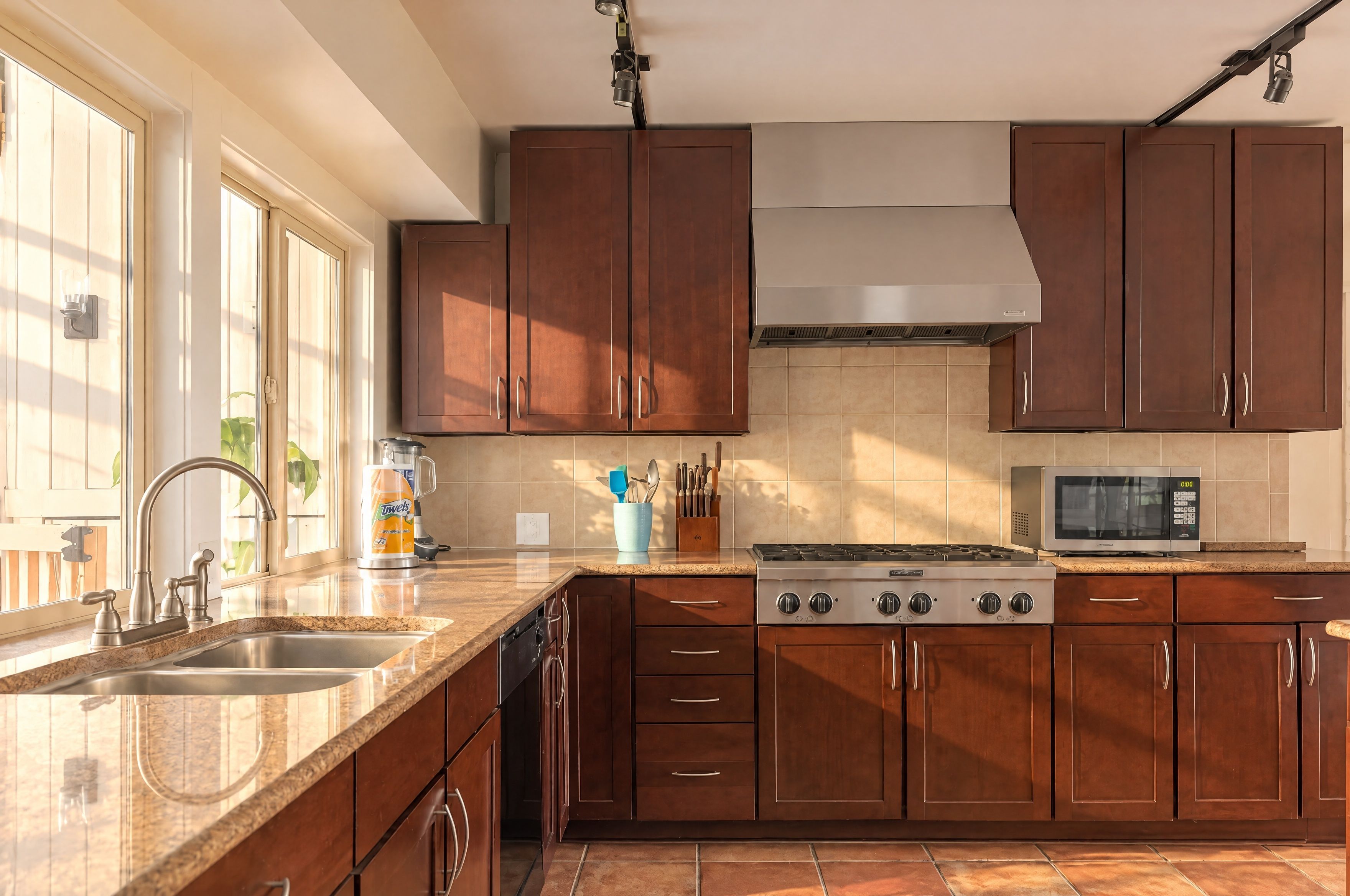 A kitchen with a stainless steel range, a microwave, and a dishwasher.