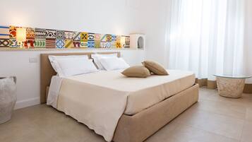 A neatly arranged bedroom with a bed, pillows, a bedside table, and a wall-mounted shelf with decorative items.
