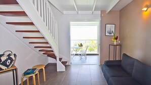 A modern interior with a staircase, a balcony, and a seating area. - "O Coeur de Deshaies" (Deshaies)