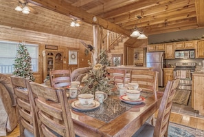 A wooden cabin interior with a dining table set for four, surrounded by wooden chairs. - Luxury! 2 Master Suites w/Fireplaces|Game Room (SEVIERVILLE)