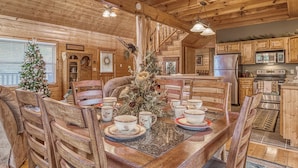 A wooden cabin interior with a dining table set for four, surrounded by wooden chairs. - Luxury! 2 Master Suites w/Fireplaces|Game Room (SEVIERVILLE)